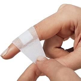 Kobieta nakładająca na palec plaster