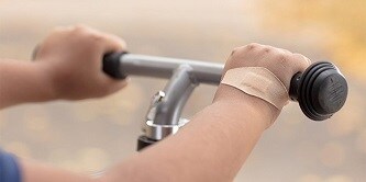 Plaster Viscoplast™ DUO przyklejony na ręce dziecka jadącego na rowerze
